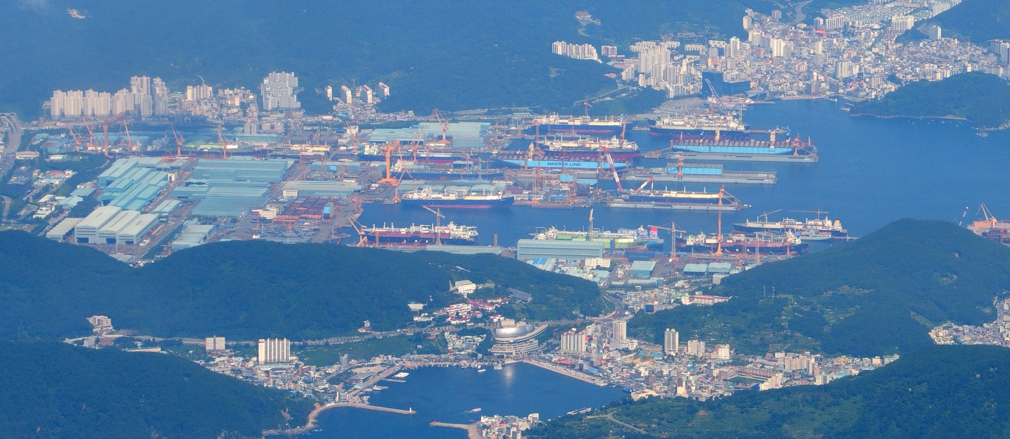 The Okpo shipyard on Geoje Island seen from the air: docks, gantry cranes and ships under construction